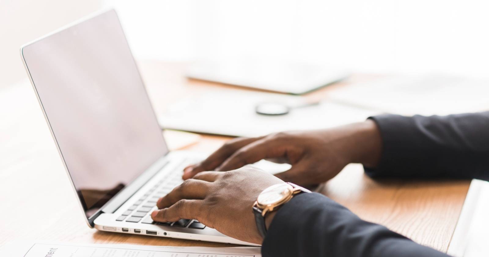 Две руки печатают на ноутбуке