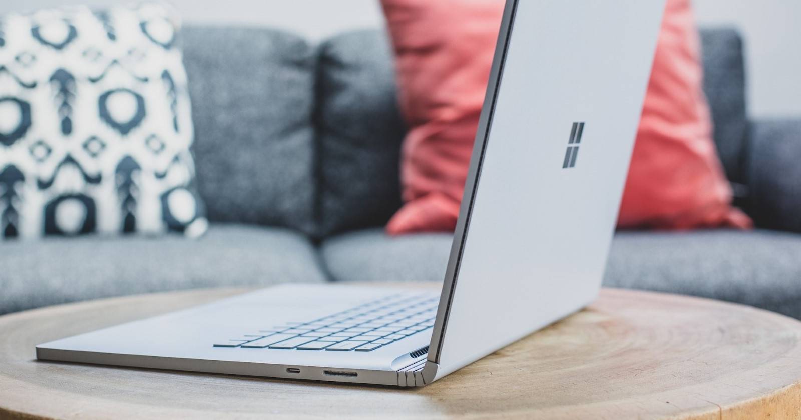 Серебристый ноутбук с Windows на круглом деревянном столе