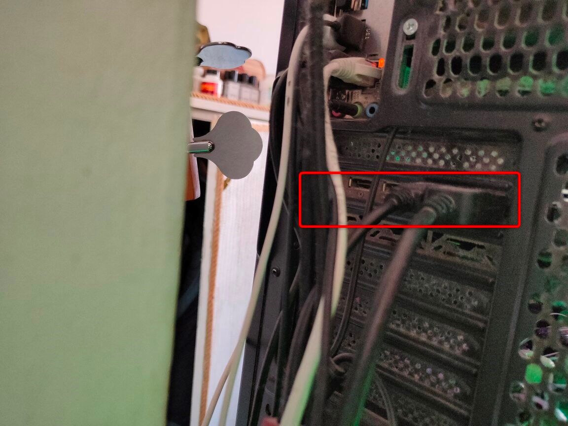 Задняя панель компьютера с фокусом на видеовыходах видеокарты.