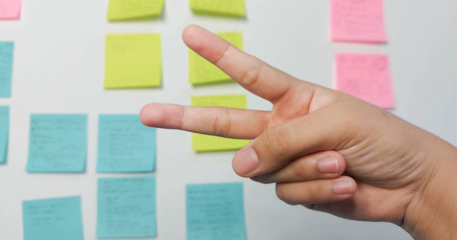 Человек показывает жест «ножницы» рукой