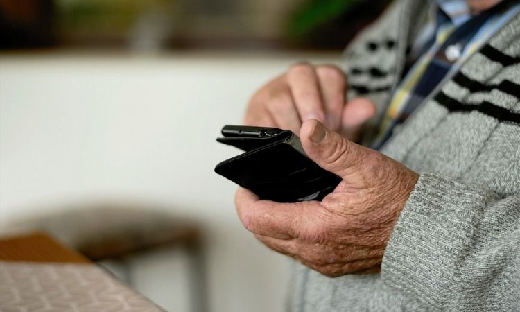 Пожилой мужчина разговаривает по телефону.