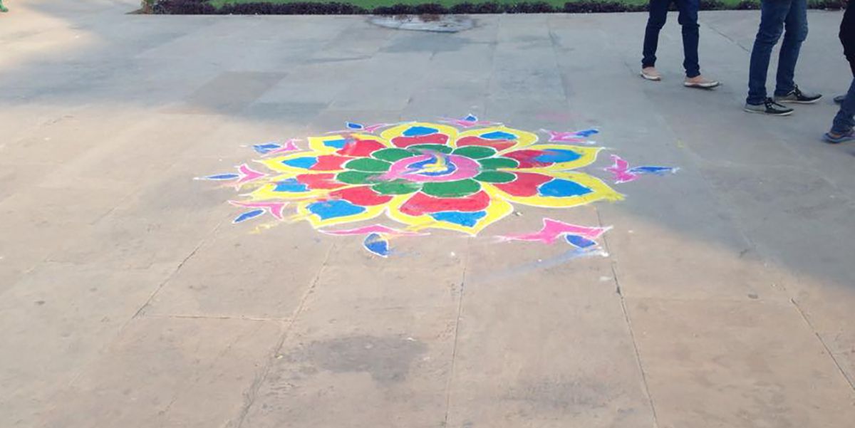 Colorful sand mandala on ground.
