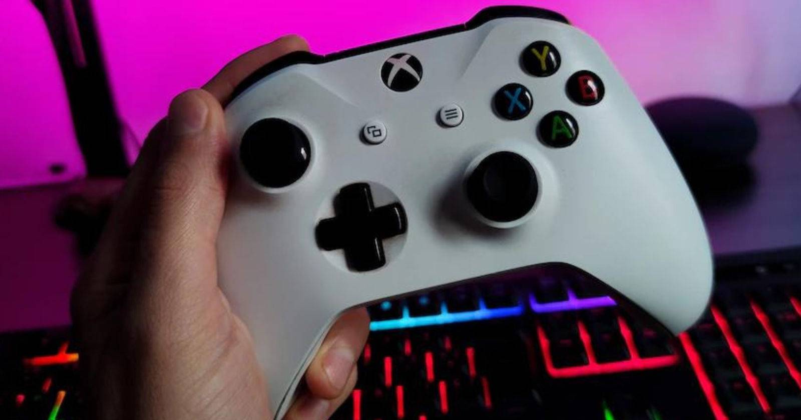 Person holding a white Xbox Series X S Controller over RPG Keyboard
