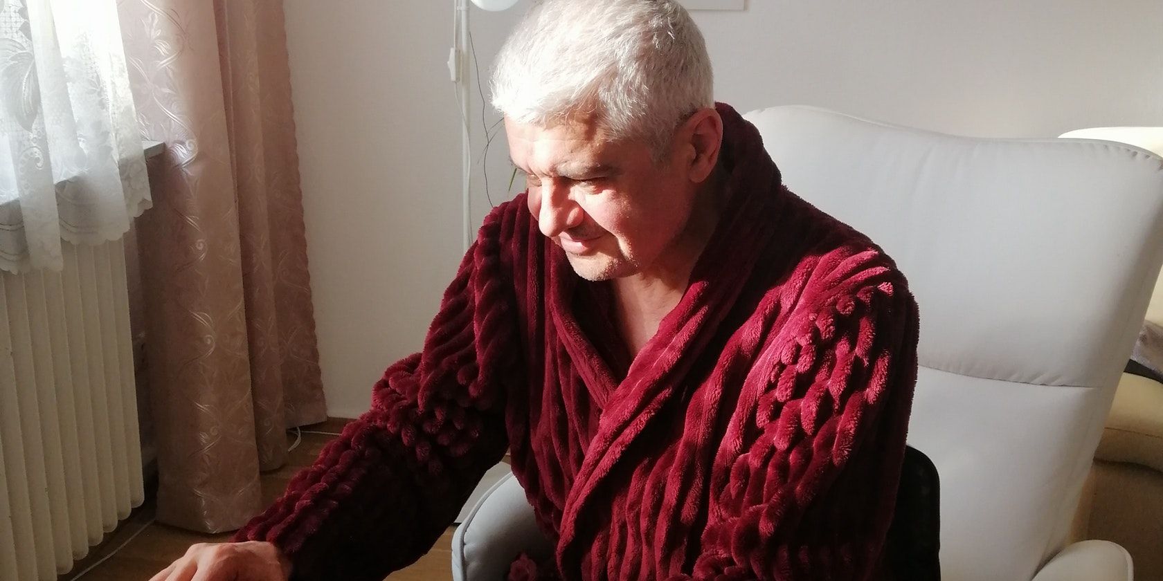 Пожилой мужчина работает за ноутбуком