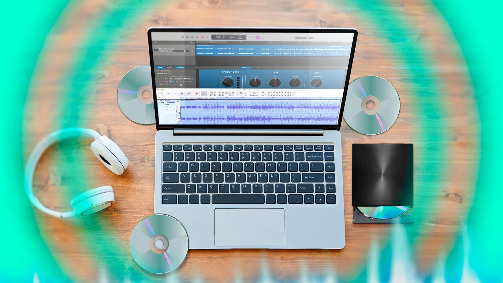 Ноутбук с открытым Audacity, внешний дисковод рядом, несколько CD вокруг и пара наушников.