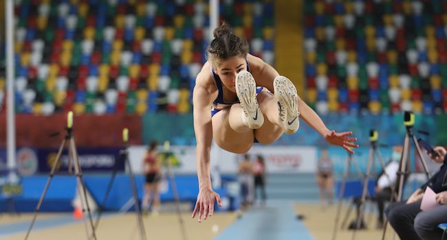 Атлет выполняет прыжок в длину на соревнованиях, спортивная сцена Олимпиады