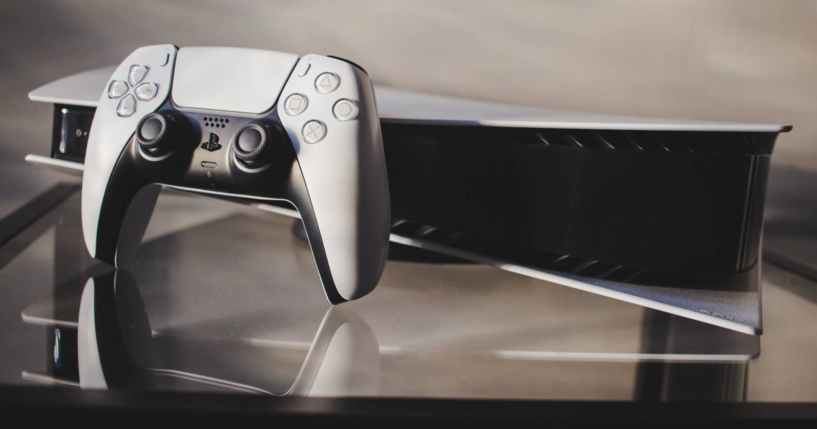 PS5 консоль и контроллер на стеклянном столе