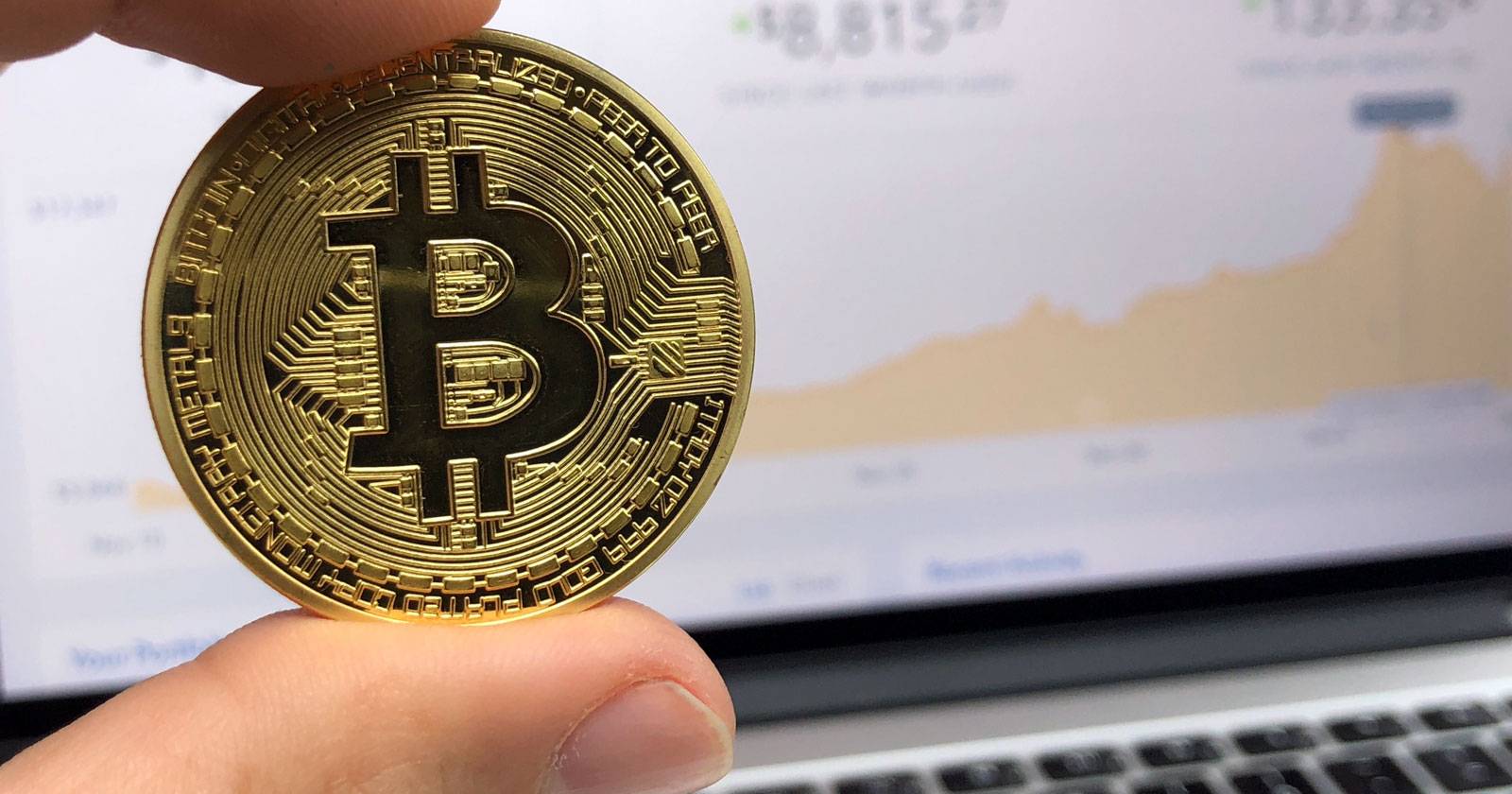 Монеты Биткоин на фоне графика и ноутбука