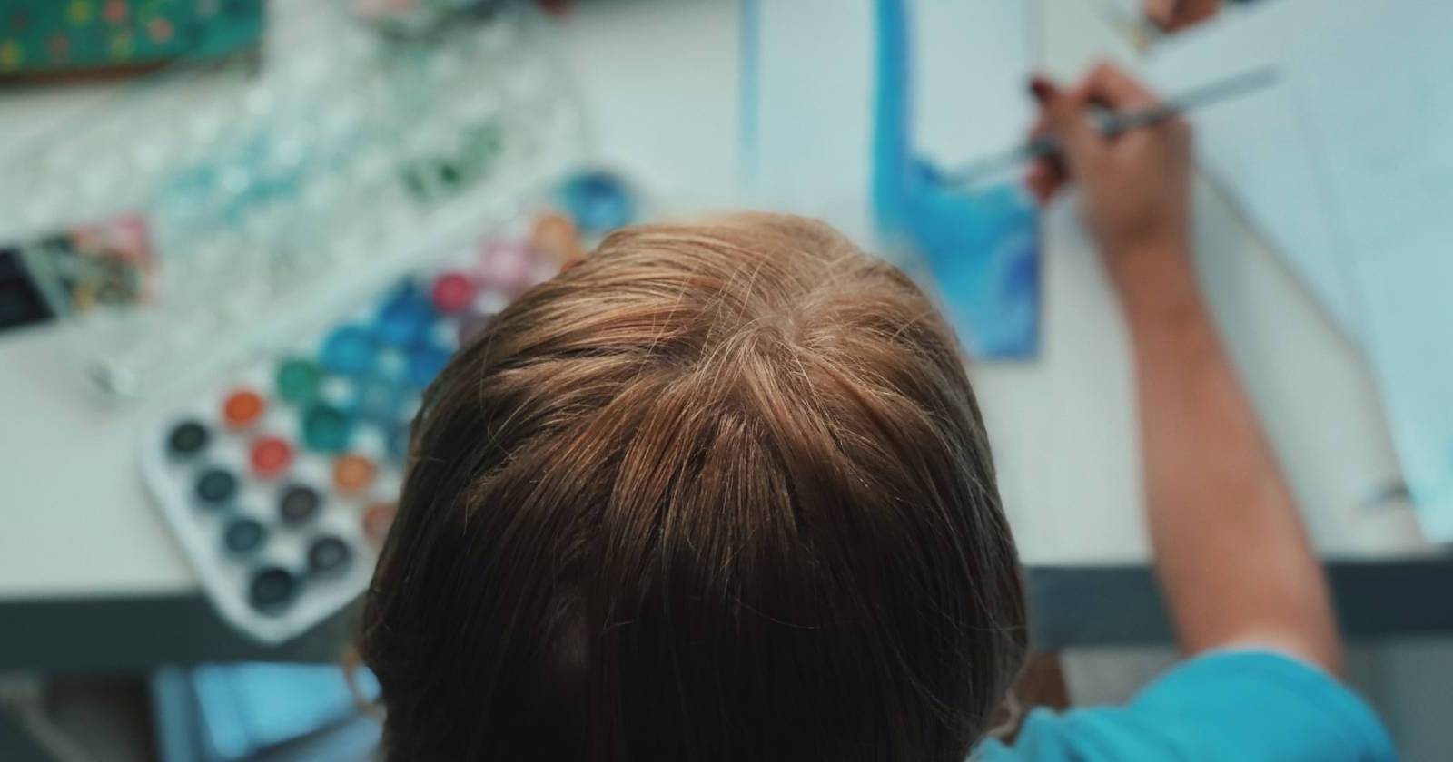 Человек выбирает хобби: инструменты, книги и гаджеты на столе для новых увлечений