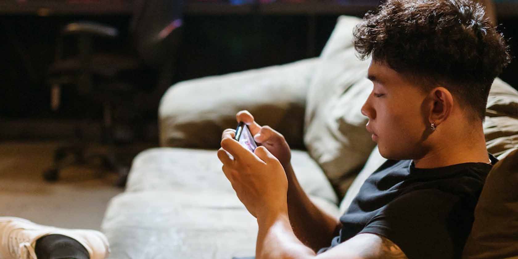 Мужчина играет в игры на телефоне