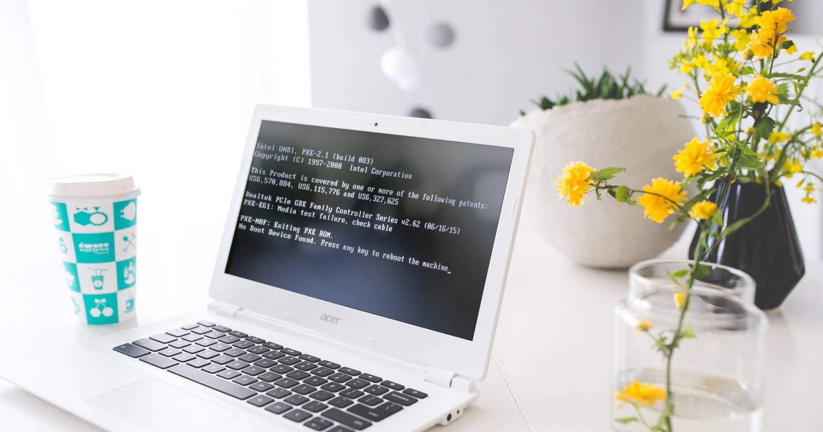테이블 위 노트북 화면에 'No Boot Device Found' 오류가 표시된 모습