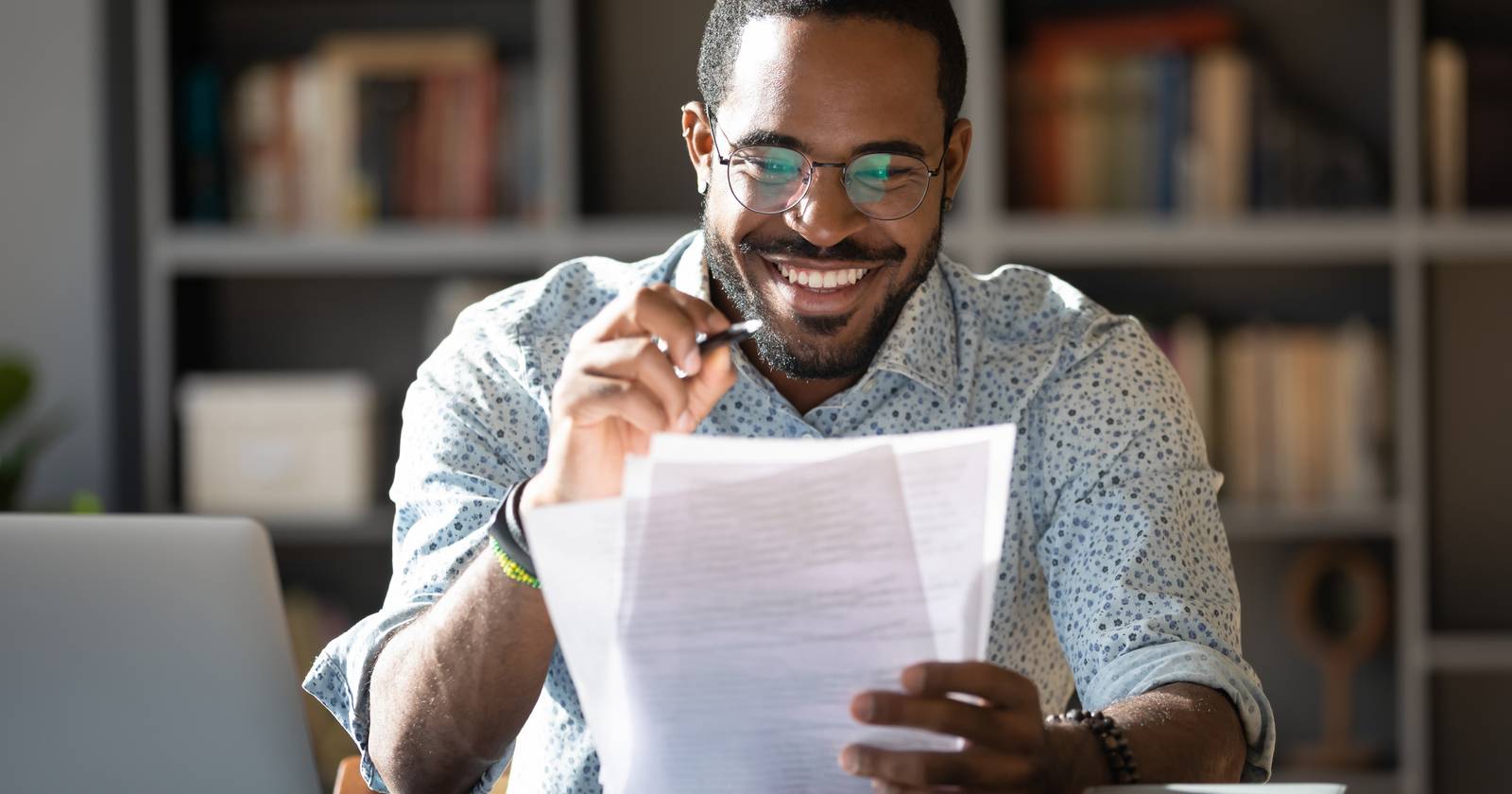 молодой человек держит листы бумаги