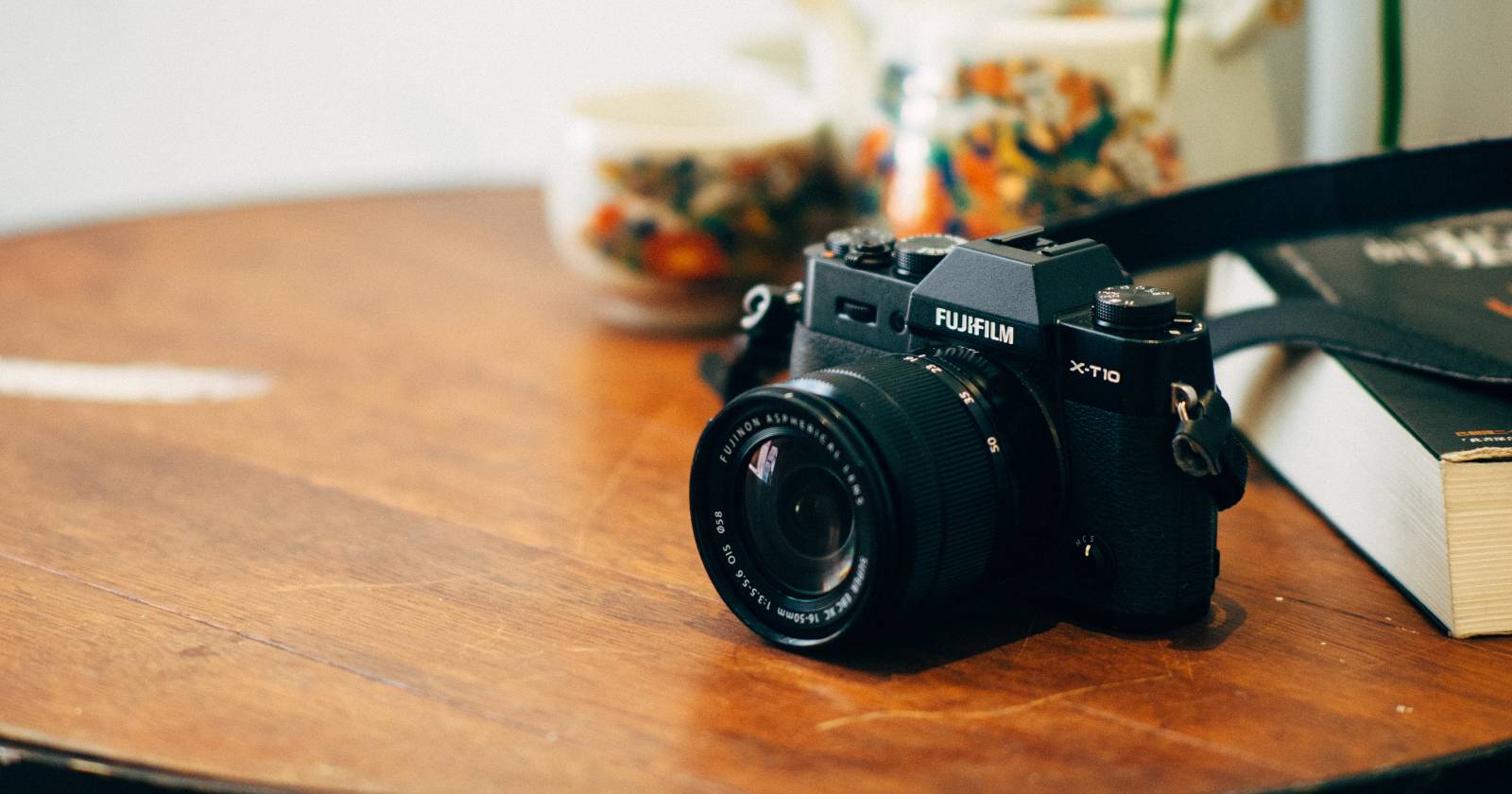 Крупный план камеры Fujifilm на столе, видны объектив и элементы управления