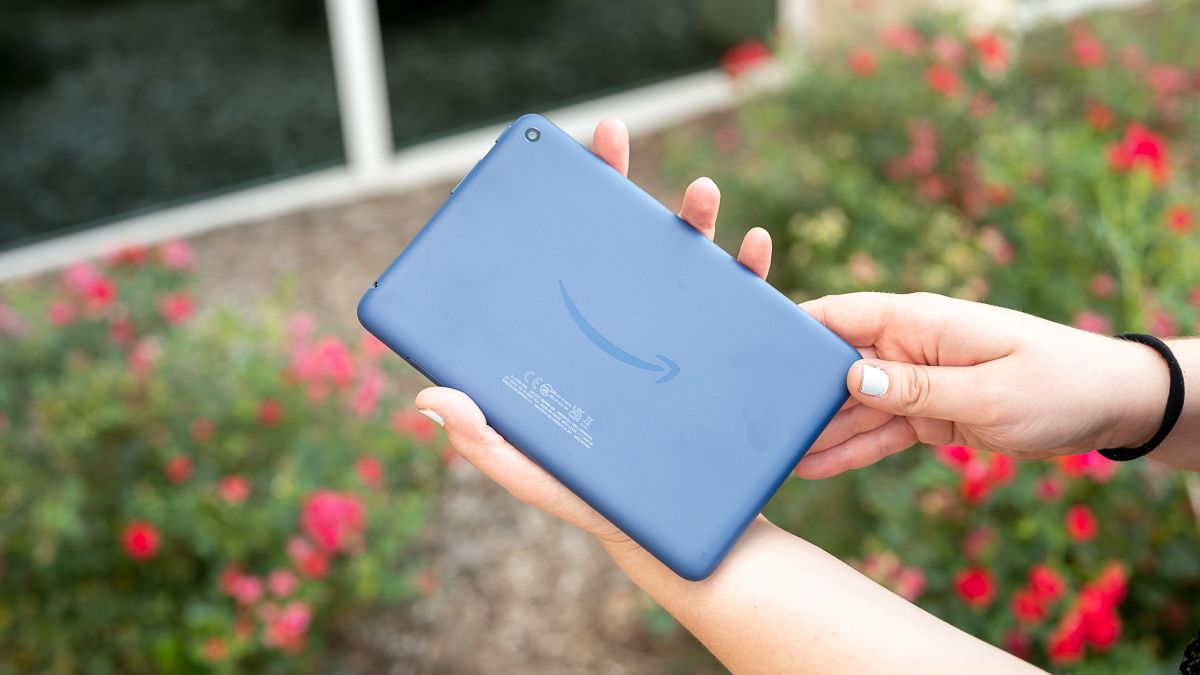 Человек держит планшет Amazon Fire 7 (2022) синего цвета