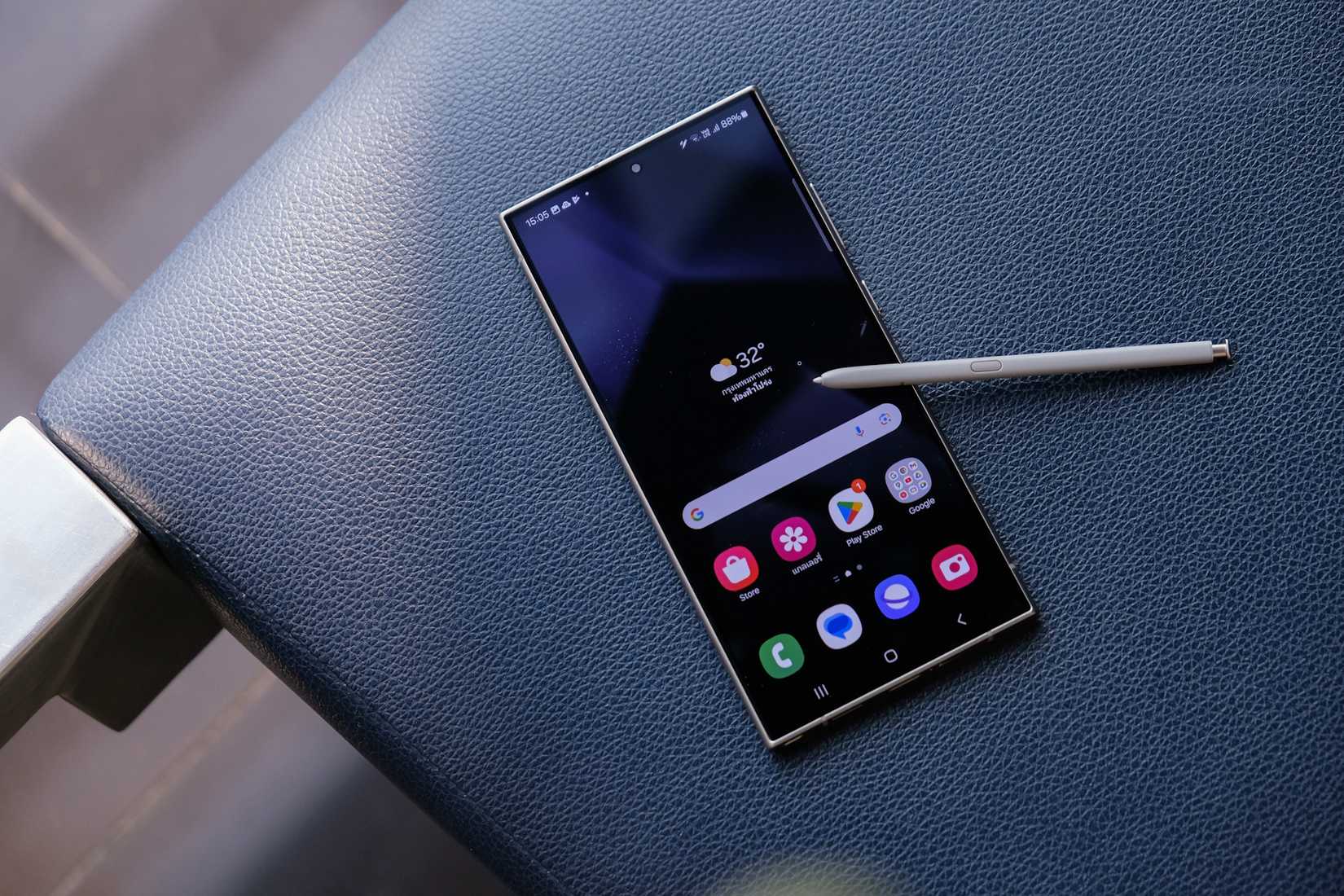 Galaxy S24 Ultra с S Pen на краю сиденья.