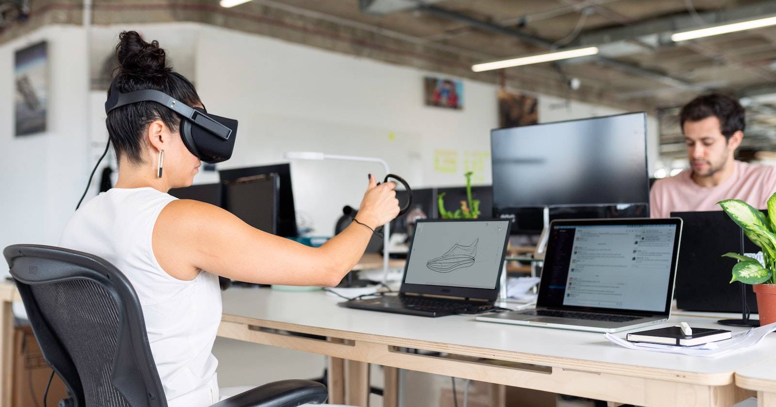 Женщина за ноутбуком в очках виртуальной реальности