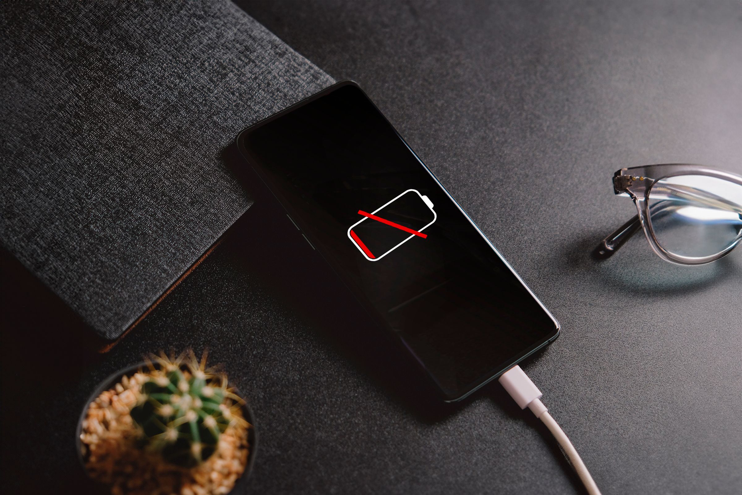 Android‑смартфон на зарядке с разряженной батареей.