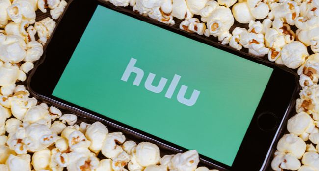 Экран смартфона с логотипом Hulu и попкорном вокруг