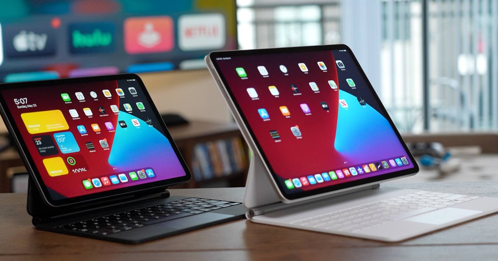 Two iPad Pros on a desk with black and silver Magic Keyboards