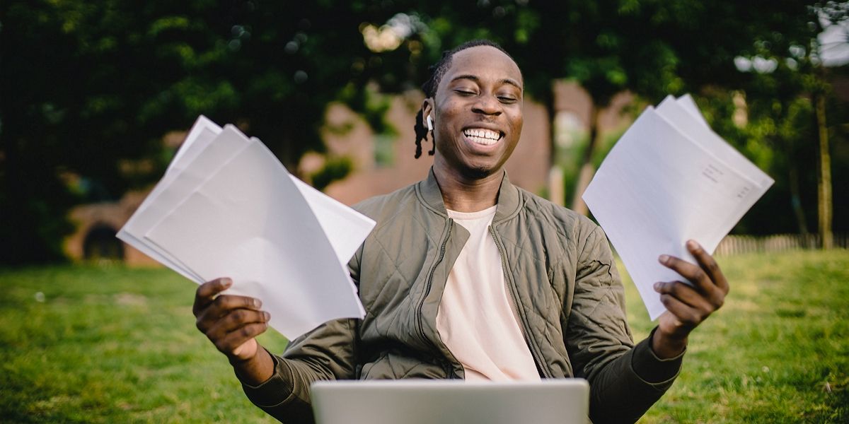 Student with documents and laptop happy about getting into university