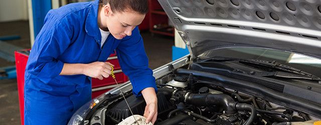 Механик проверяет уровень масла в автомобиле — пример переносимого навыка