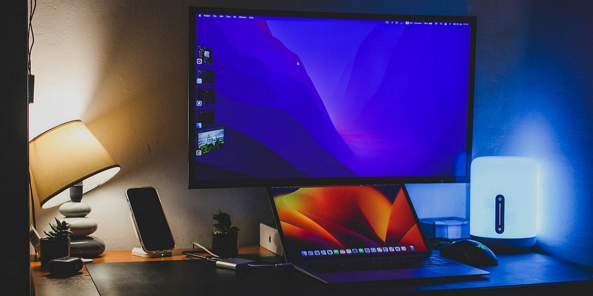 Большой монитор с ноутбуком в рабочей зоне