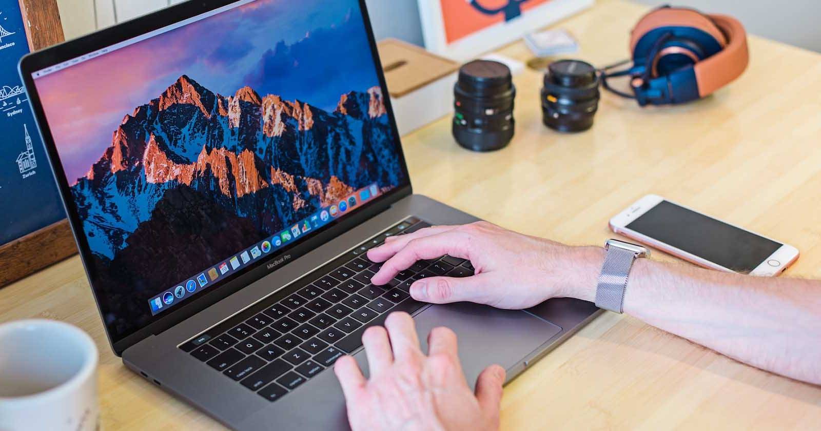 Человек использует MacBook, руки на области опоры для ладоней