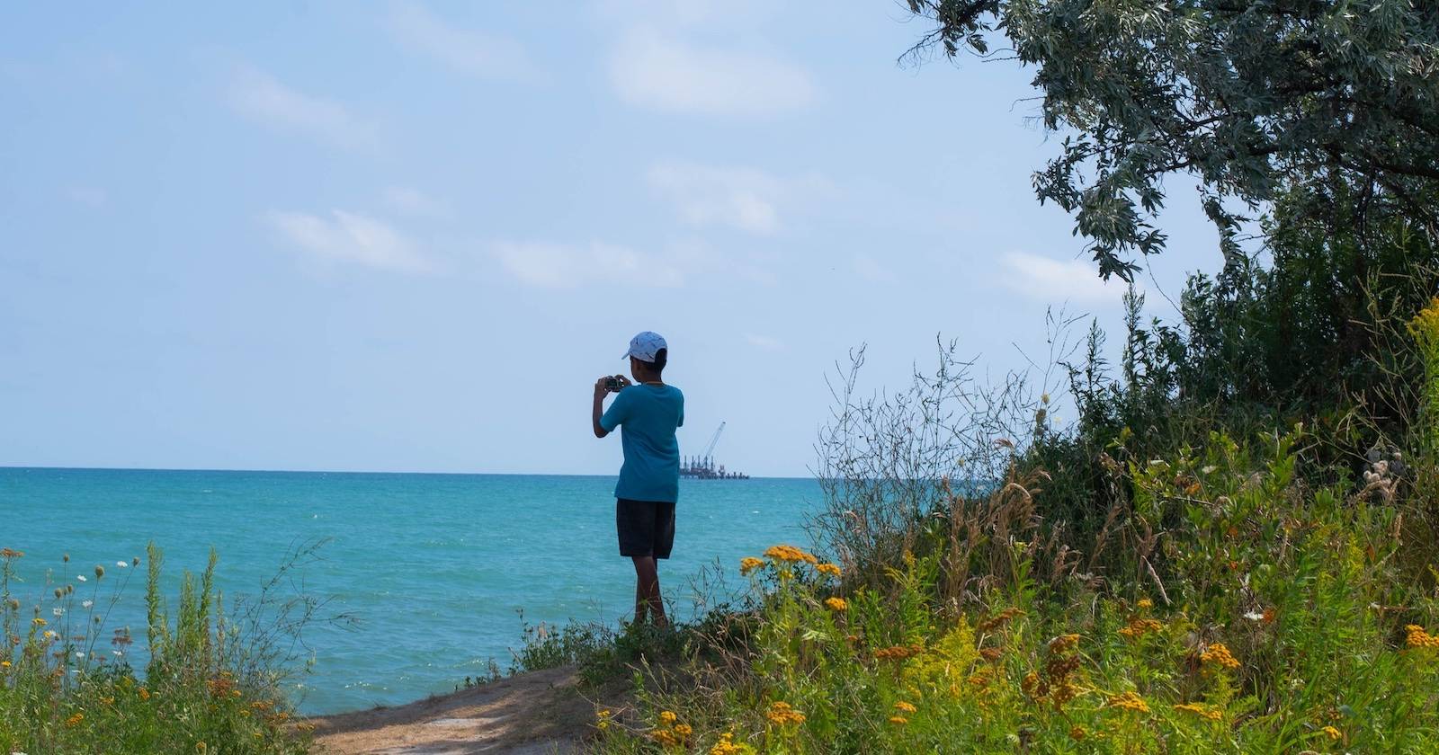 Маленький мальчик делает фотографии своим телефоном