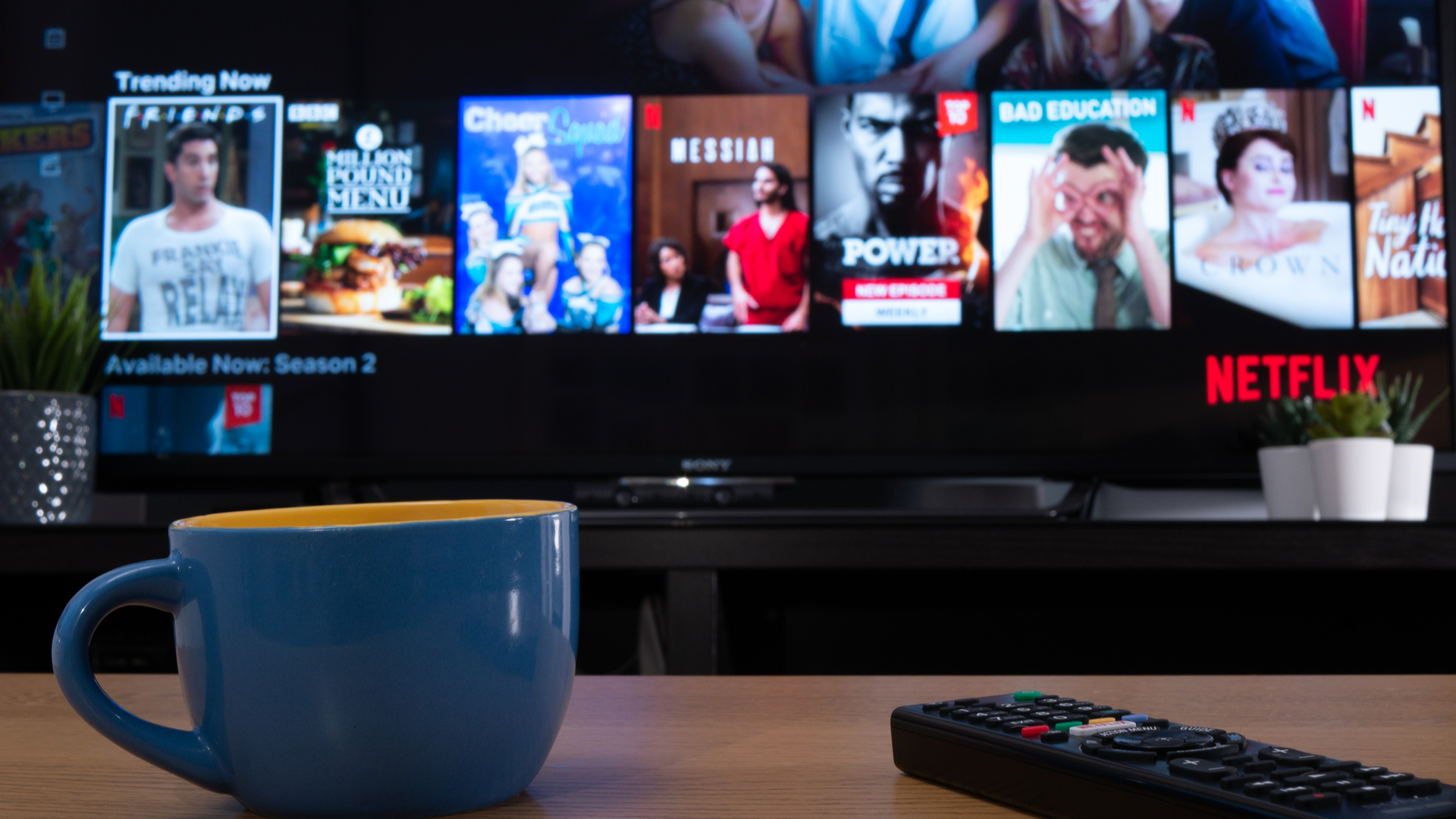 Netflix на телевизоре, на переднем плане чашка кофе
