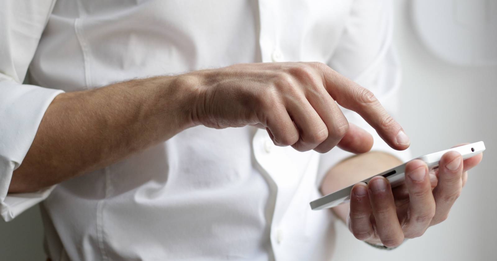 человек держит Android-телефон в руке, на экране открыто приложение сообщений