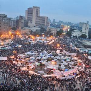 Человек держит старый плакат на протесте, символизирующий традиционный способ выражения недовольства