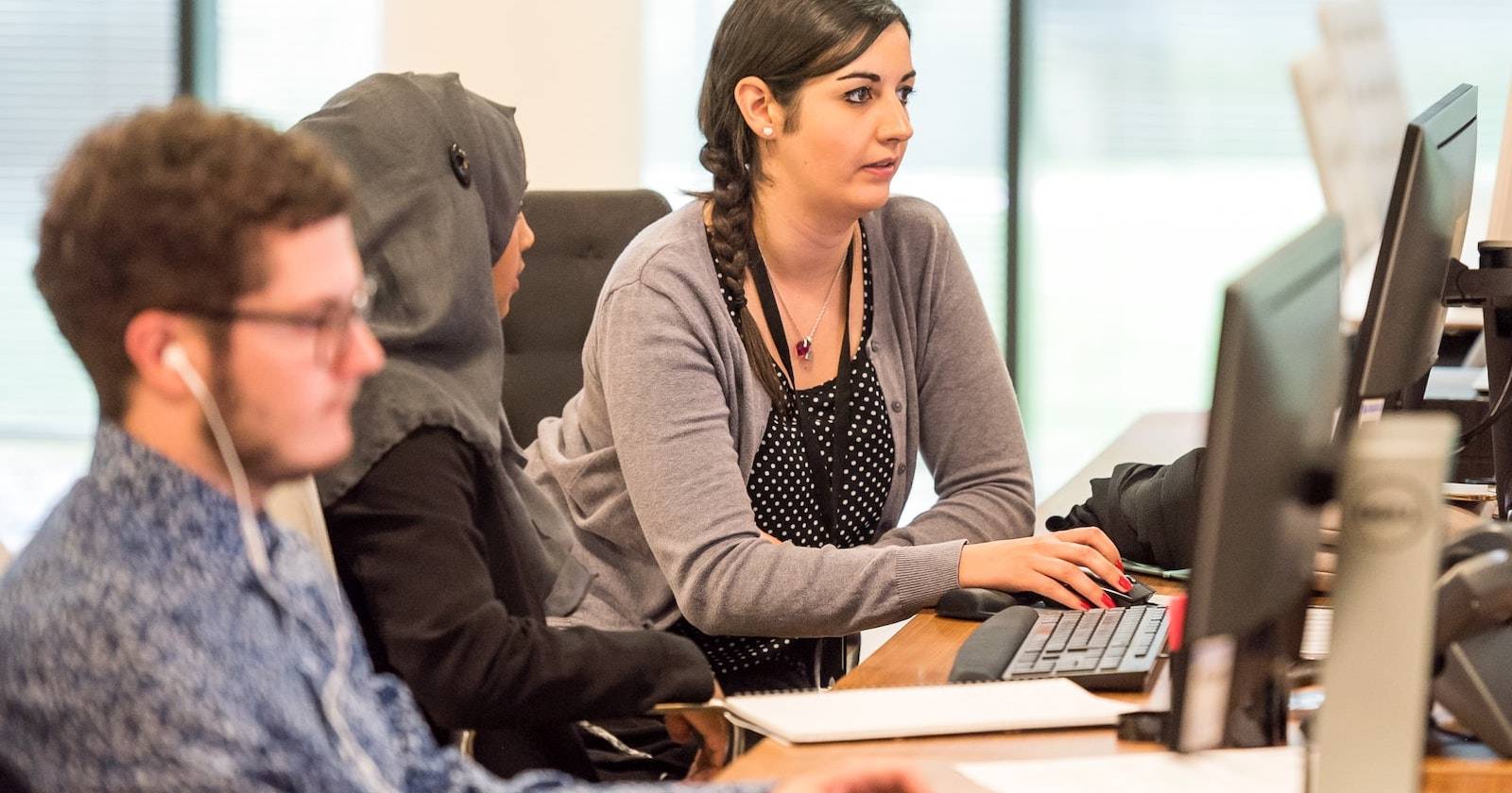 Две женщины и мужчина работают в офисе