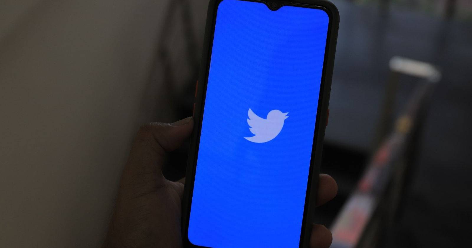 Изображение логотипа и интерфейса Twitter на экране телефона