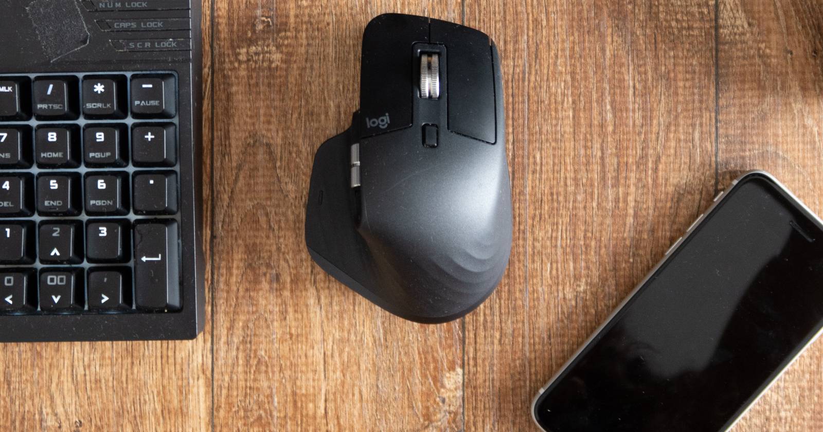 Деревянный стол с клавиатурой, мышью и телефоном