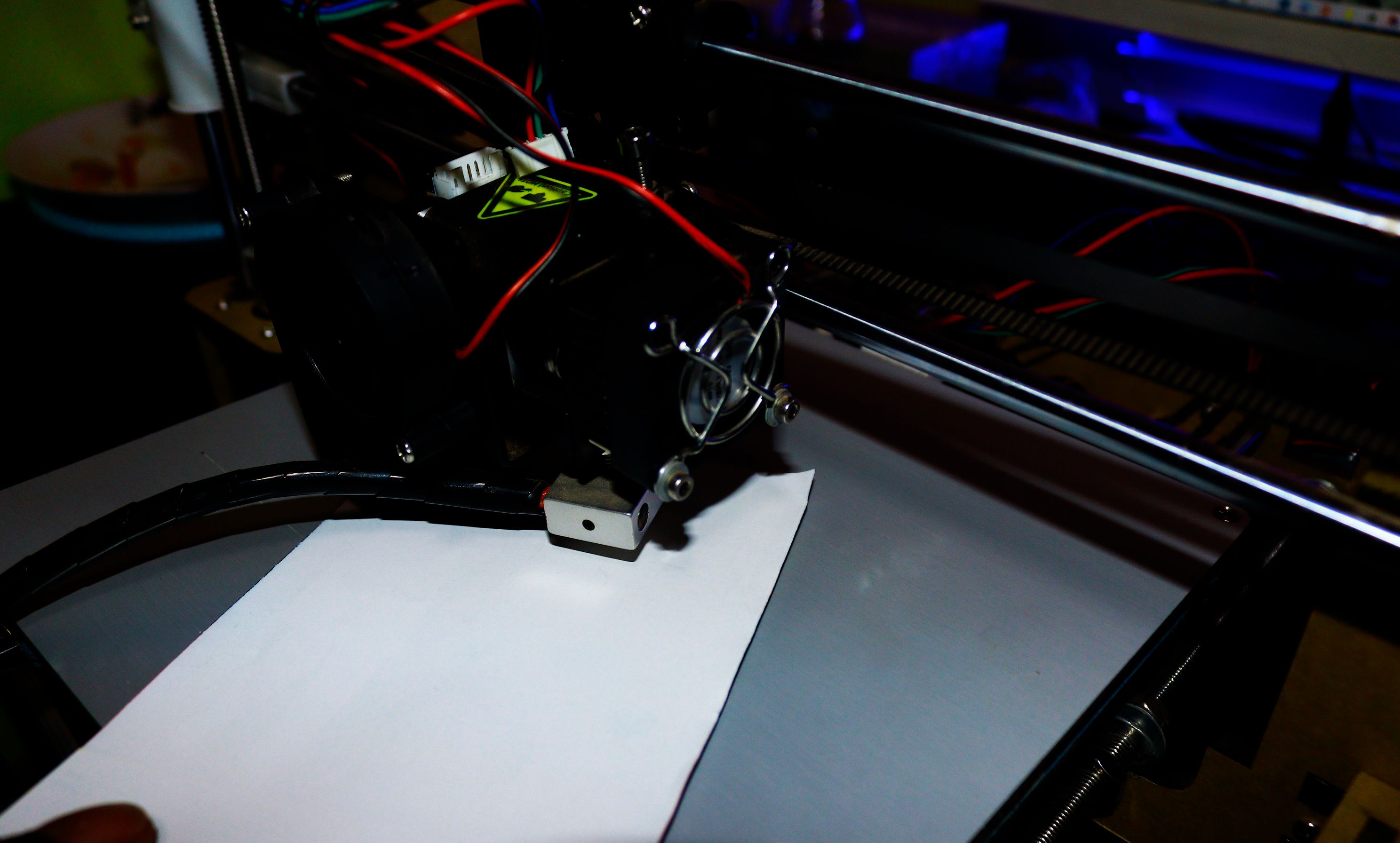 Sliding a white piece of paper below the nozzle on the 3D printer bed