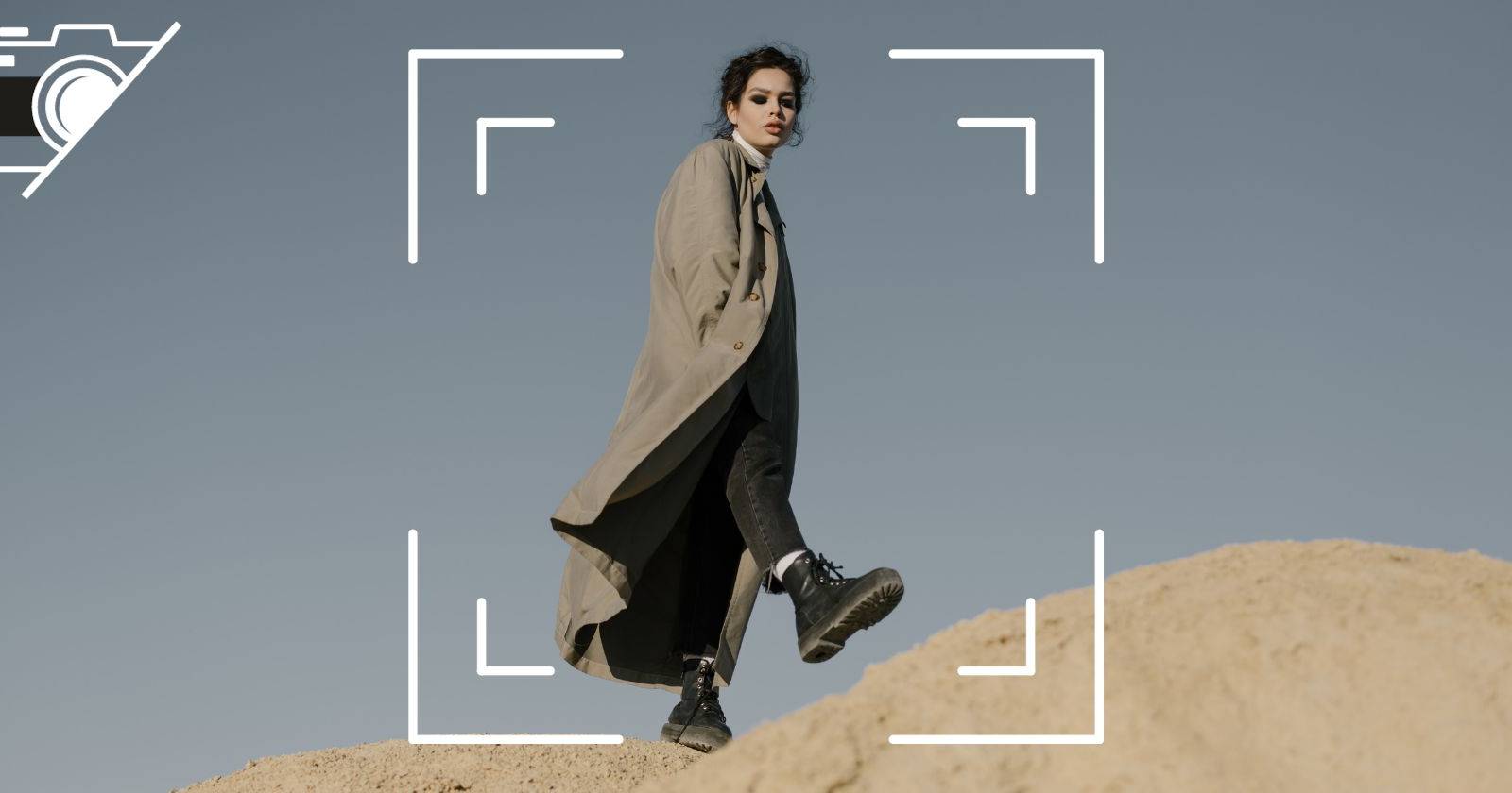 Женщина стоит на большой скале, вид сверху, с иконкой объектива камеры.