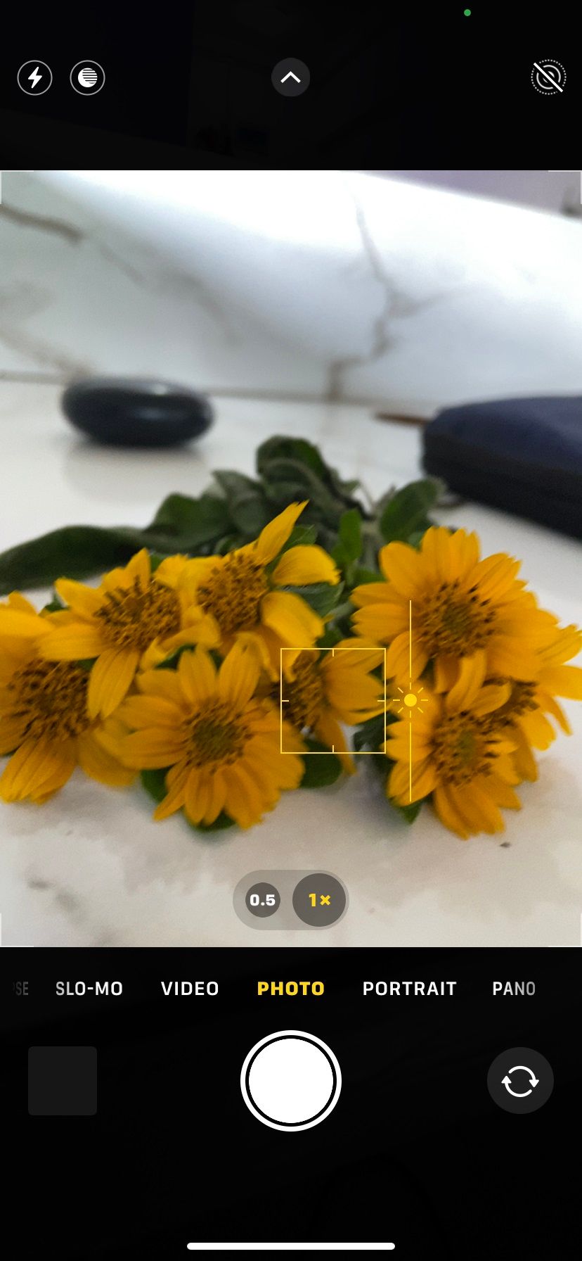 Экран смартфона с поднятым ползунком экспозиции; ползунок обозначен и показан вверх