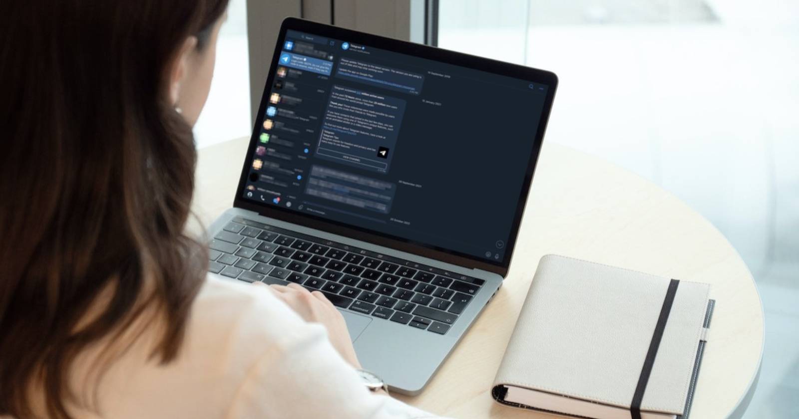 Женщина использует MacBook с открытым Telegram