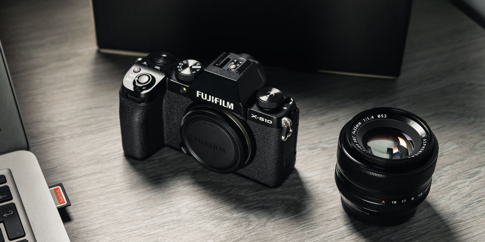 фотография камеры Fujifilm и объектива на столе