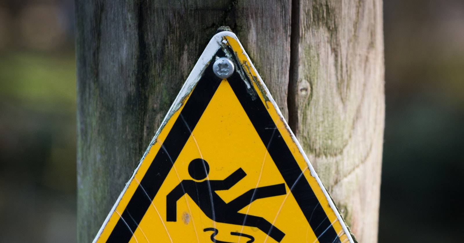 Треугольный предупреждающий знак с изображением падающего человека.