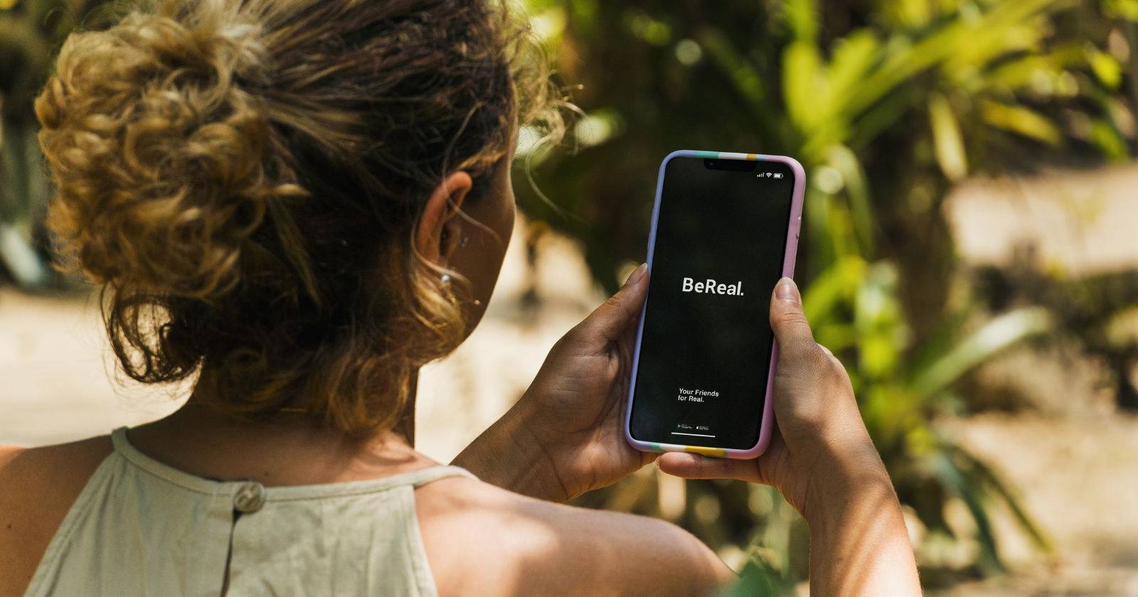 Женщина смотрит на приложение BeReal на телефоне