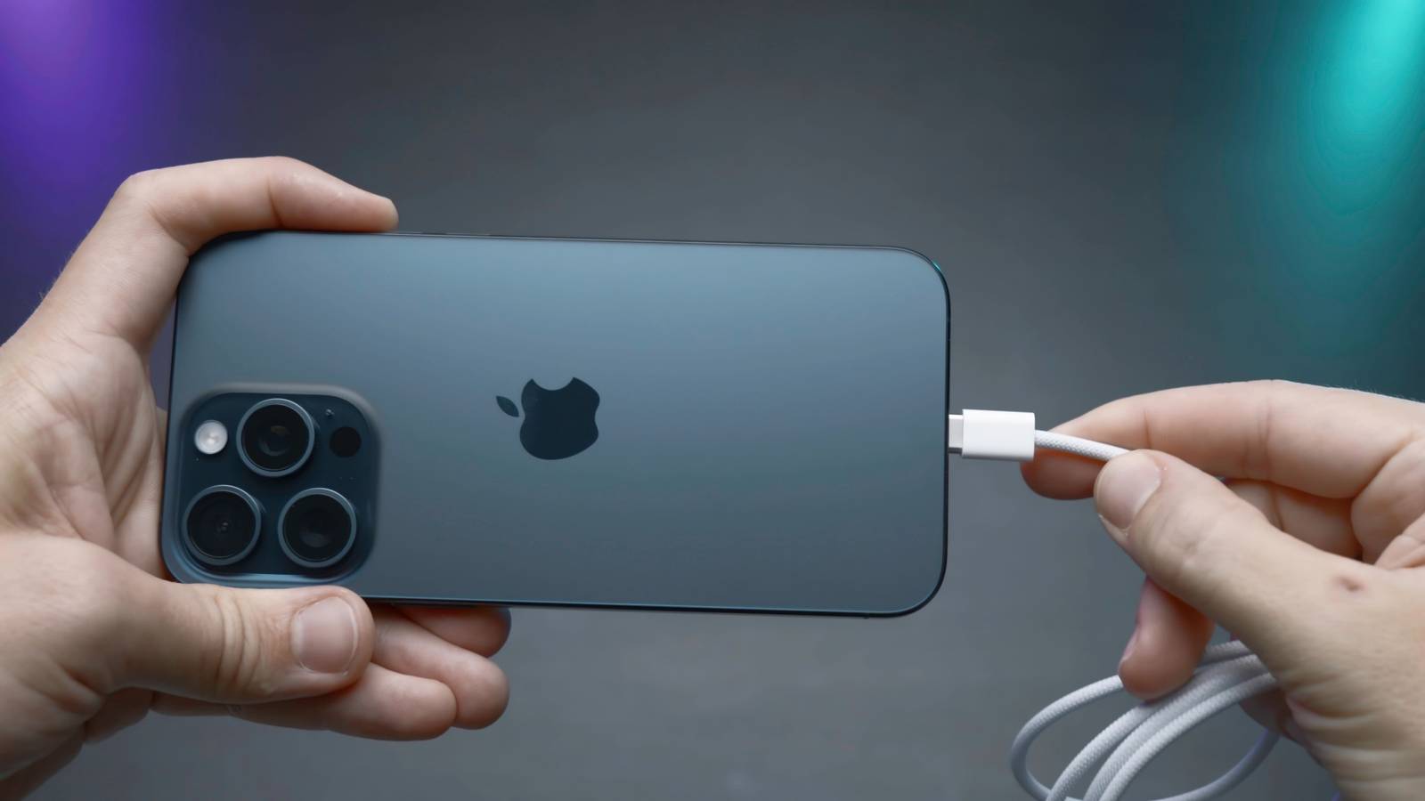 Человек вставляет кабель зарядки в iPhone