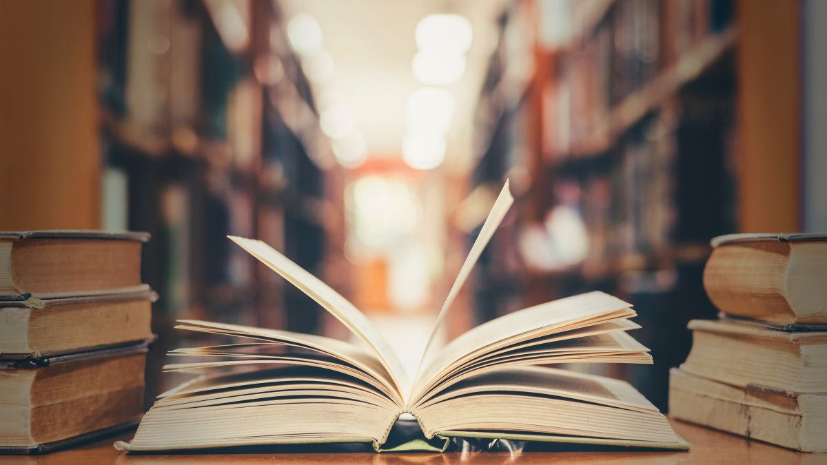 Открытая книга на столе в библиотеке.