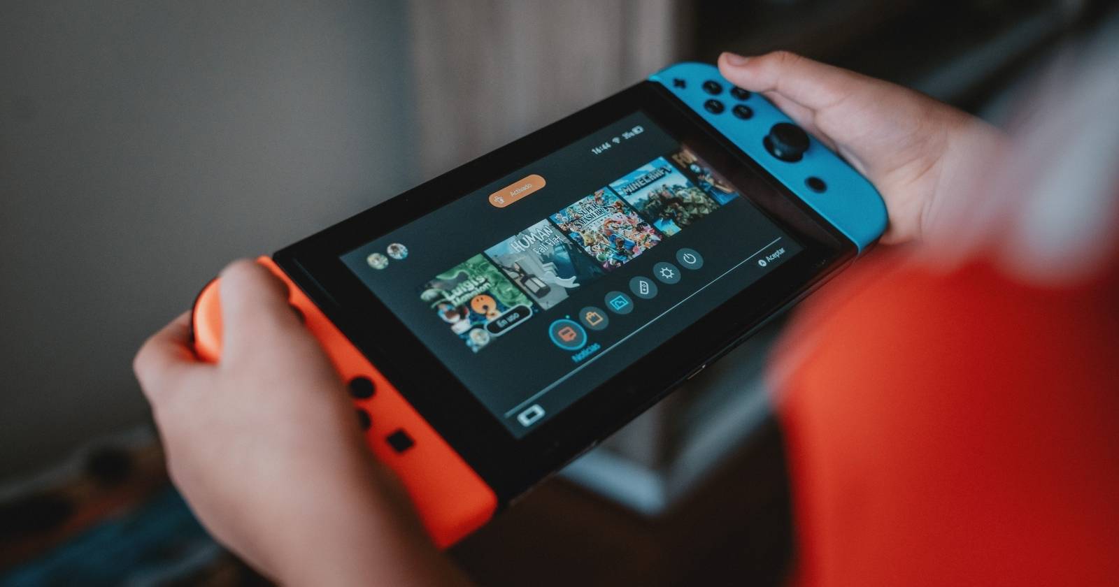 Фотография человека, играющего на Nintendo Switch в портативном режиме