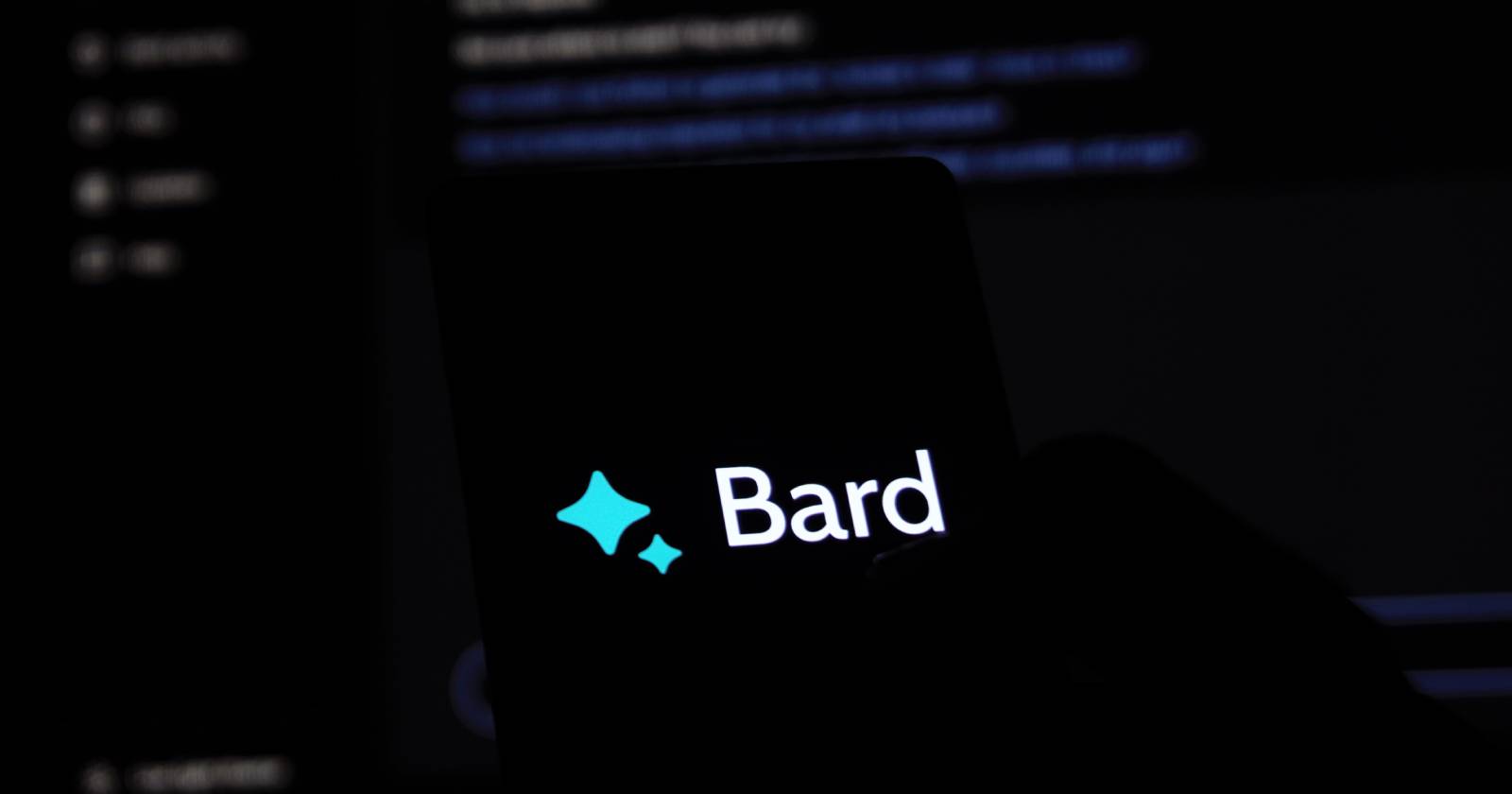 Смартфон с открытым Google Bard на фоне экрана ноутбука