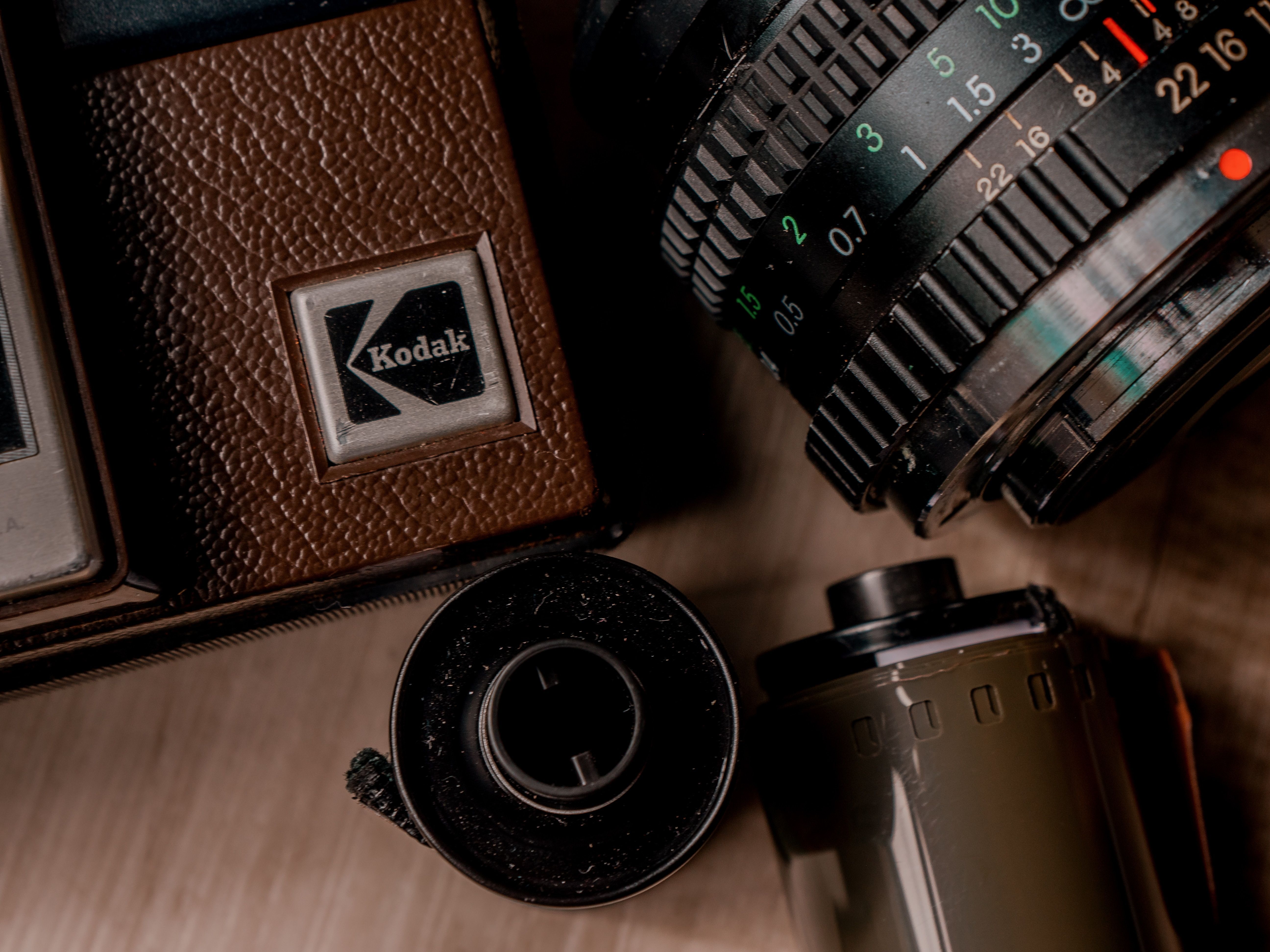 Камера, катушка плёнки и объектив на столе