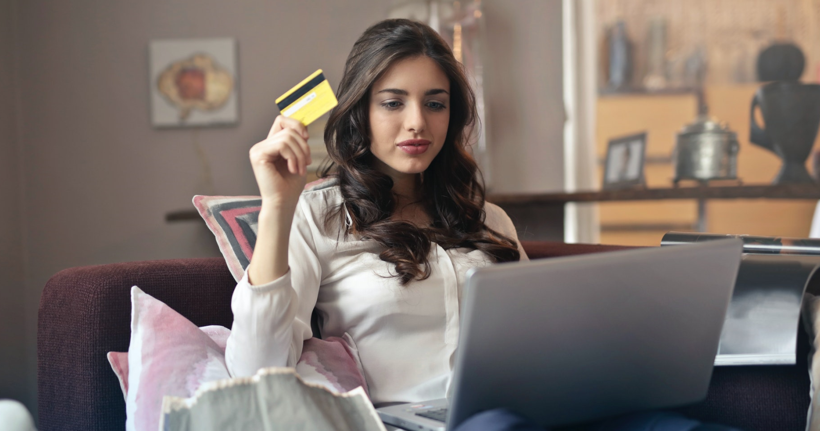 Женщина держит кредитную карту и делает покупки на ноутбуке