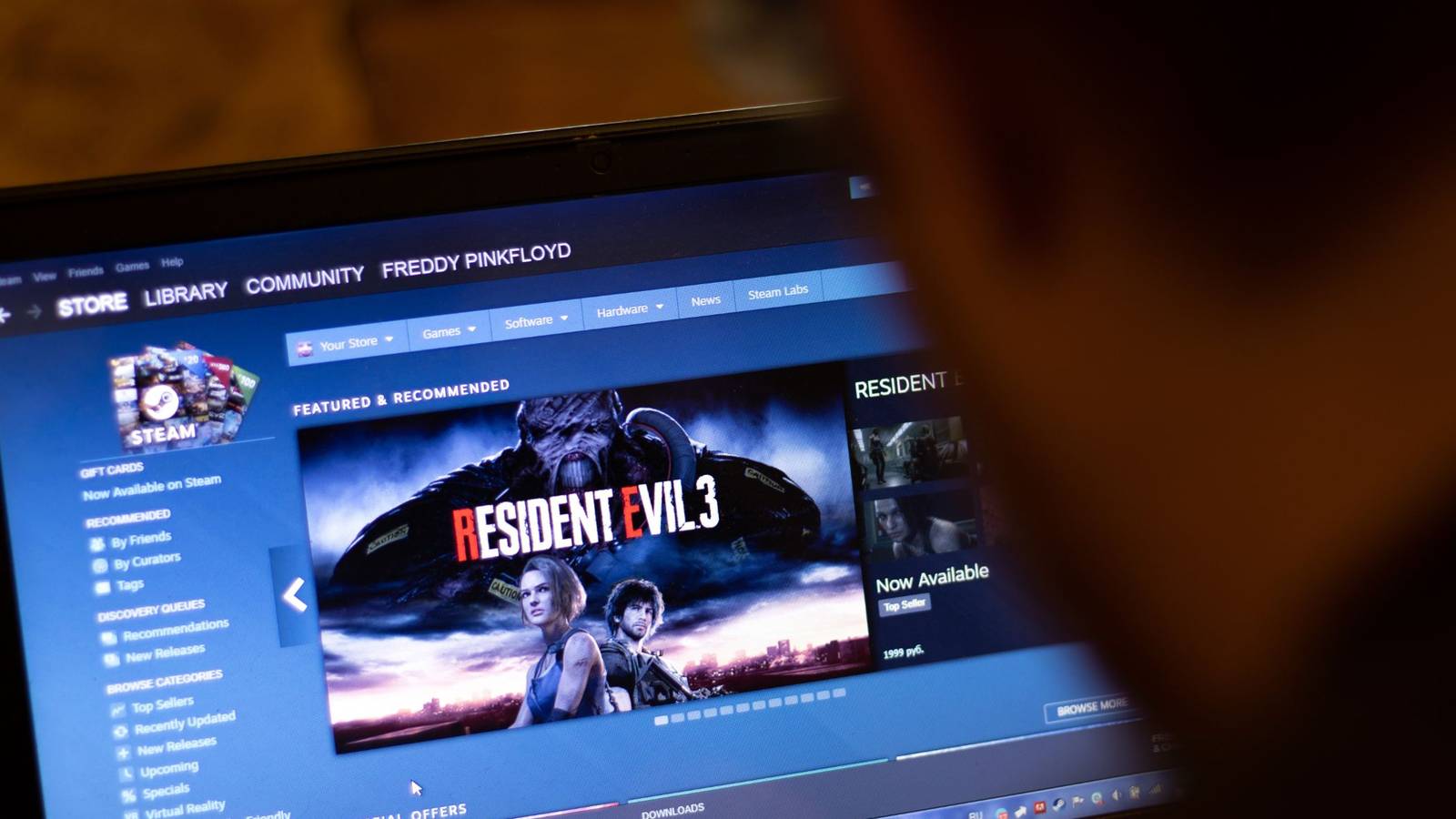 Человек использует магазин Steam на ноутбуке