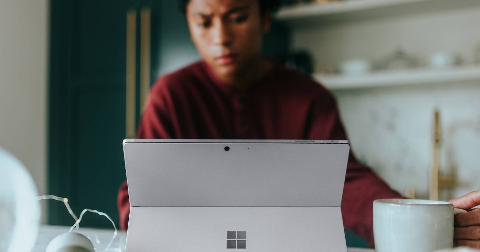 Человек работает за ноутбуком с Windows, вид сверху