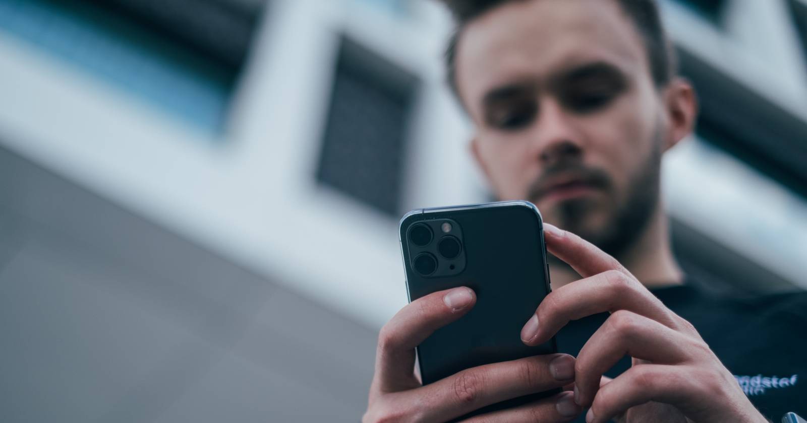 Мужчина смотрит в свой телефон, готовясь переносить номер.